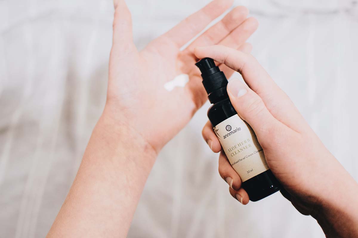 Hand applying a skincare product to address congested skin for a smoother appearance.