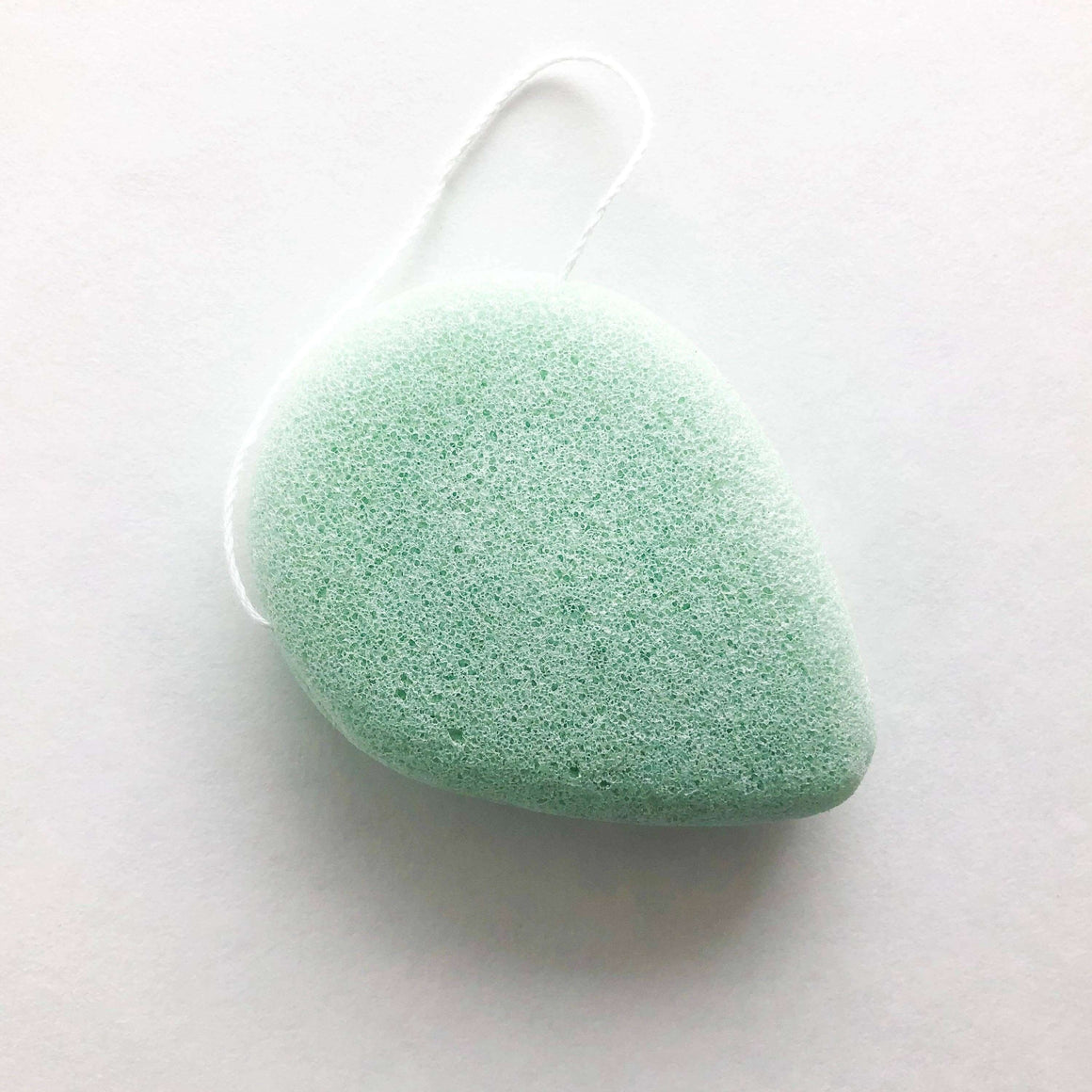 Green konjac sponge on a white background