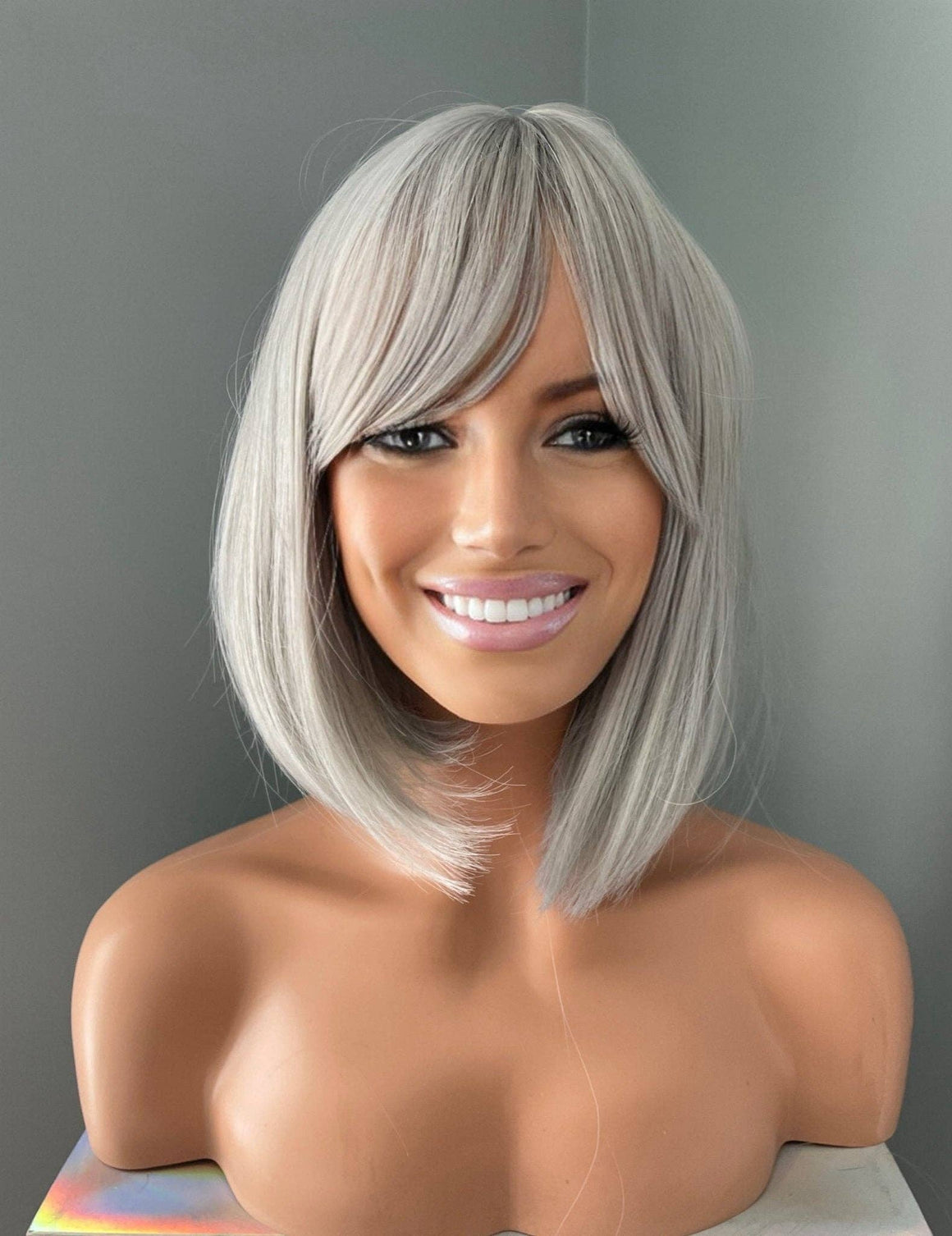 Yvette Short Silver Bob Wig featuring soft side-swept bangs and polished elegance on a mannequin.