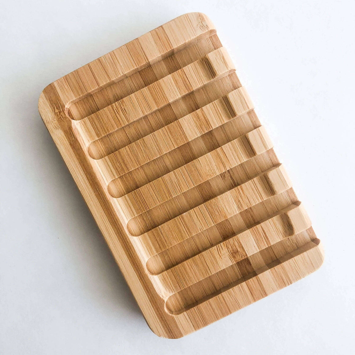 Wooden soap dish with grooves on a white background