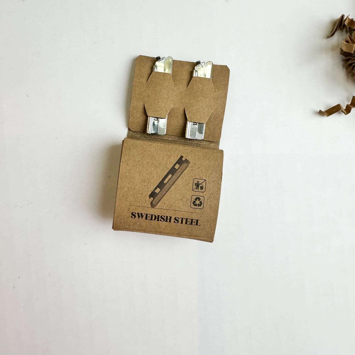 Open cardboard packaging with suspenders labeled 'Swedish Steel' on a white background