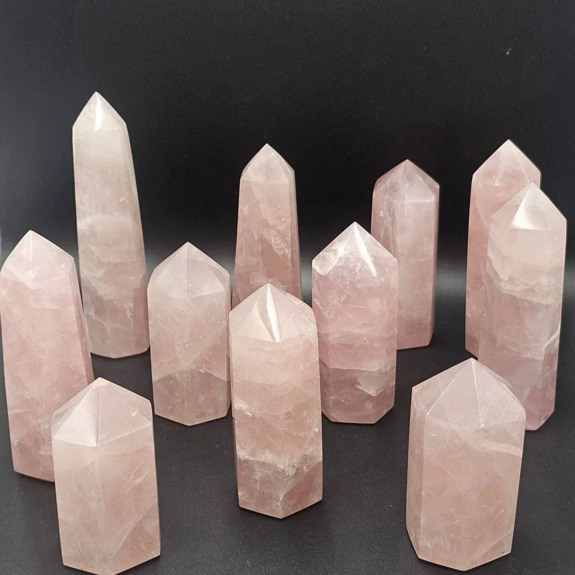 Set of rose quartz crystal points on a dark background