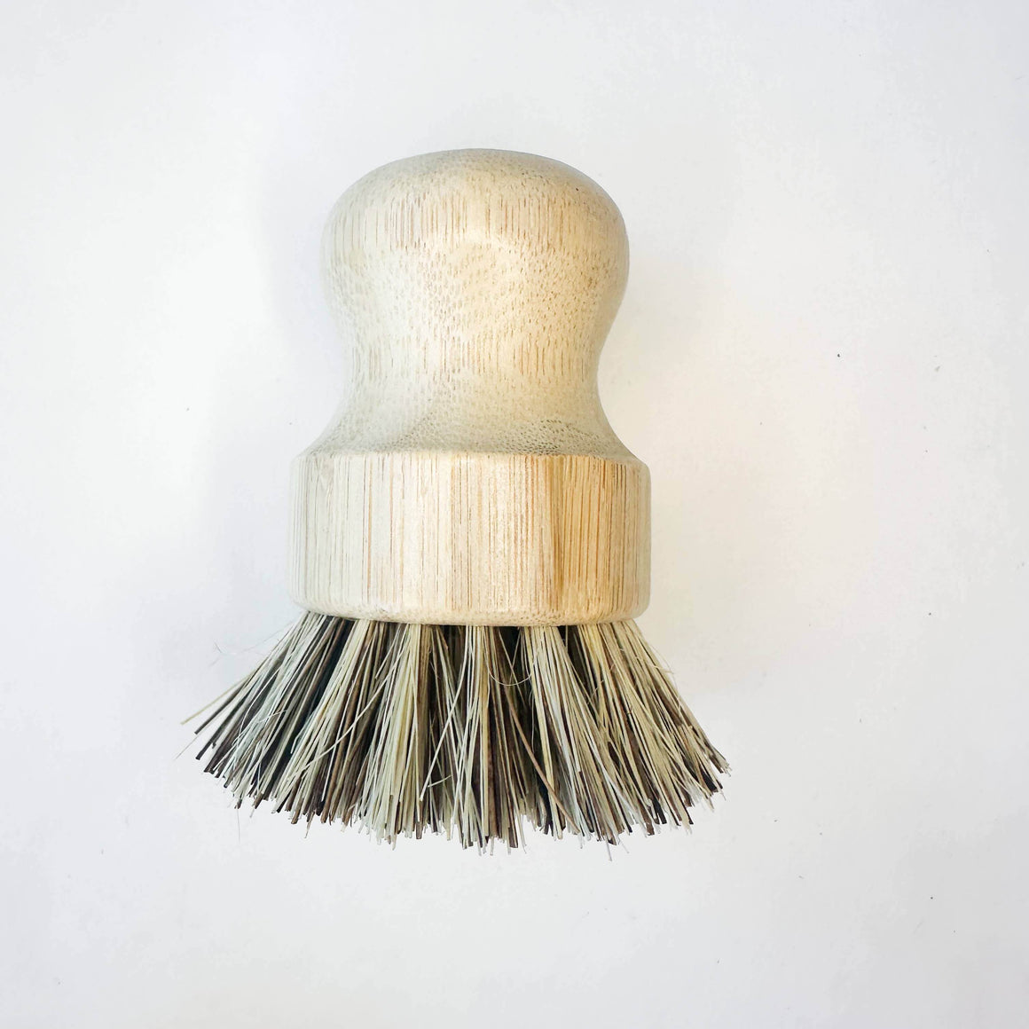 Dishwashing brush with wooden handle and bristle head on a white background