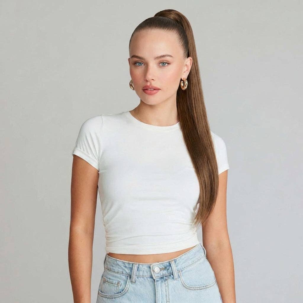 Model showcasing auburn brown ponytail hair extension with silky straight texture in a white top.