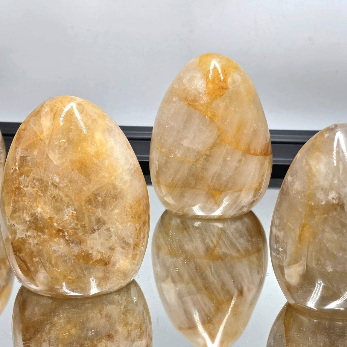 Oval-shaped stones with a reflective surface on a white background