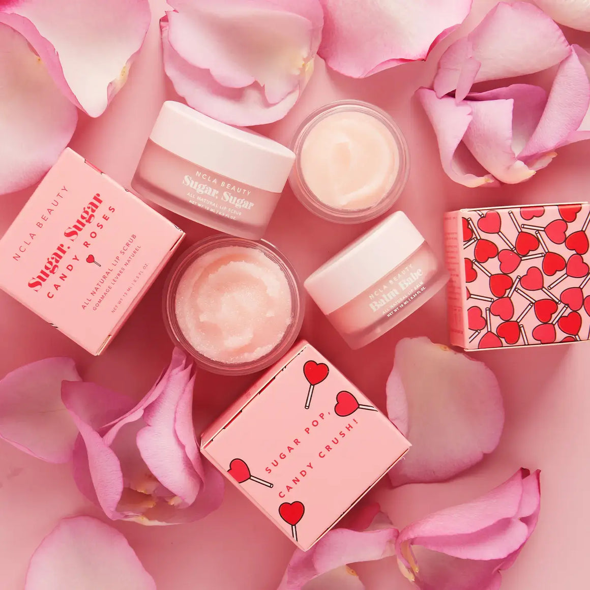 Balm Babe Candy Roses Lip Balm surrounded by rose petals, highlighting the sweet floral scent.