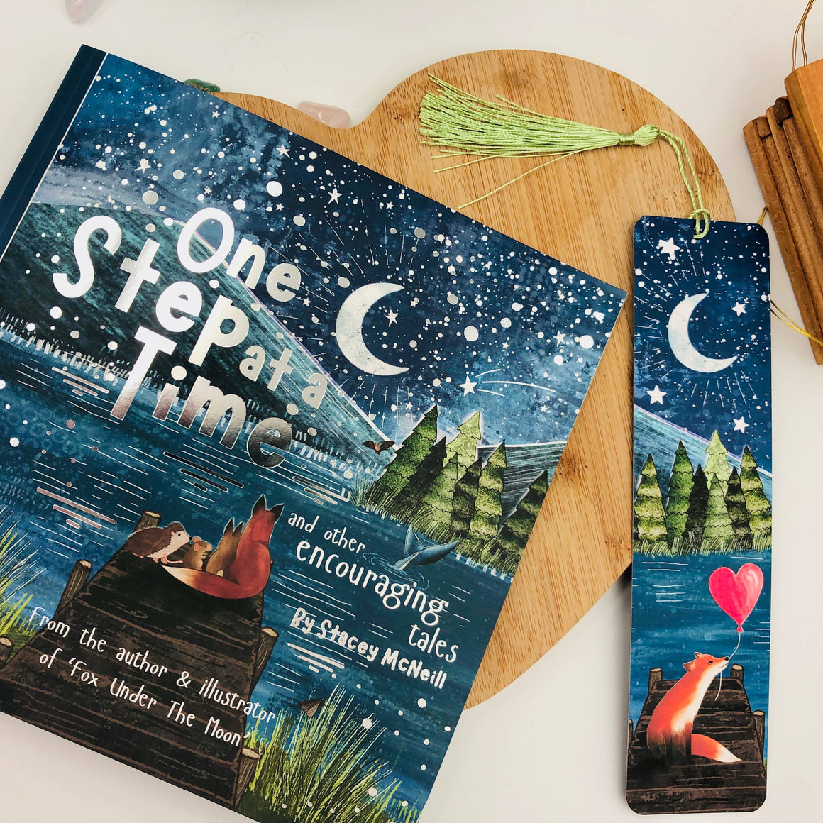 Book titled 'One Step at a Time' with a matching bookmark on a wooden heart-shaped board.