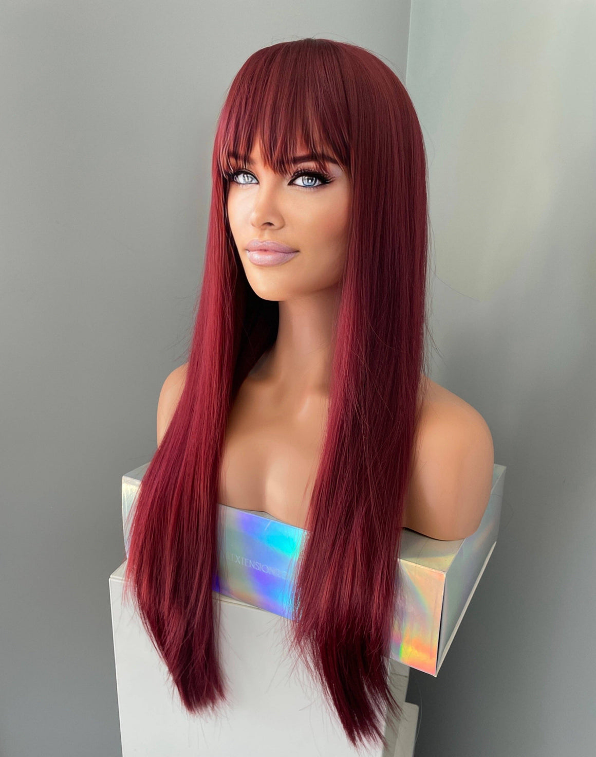 long wine red silky straight wig with bangs displayed on a mannequin, showcasing its sleek and vibrant appearance.