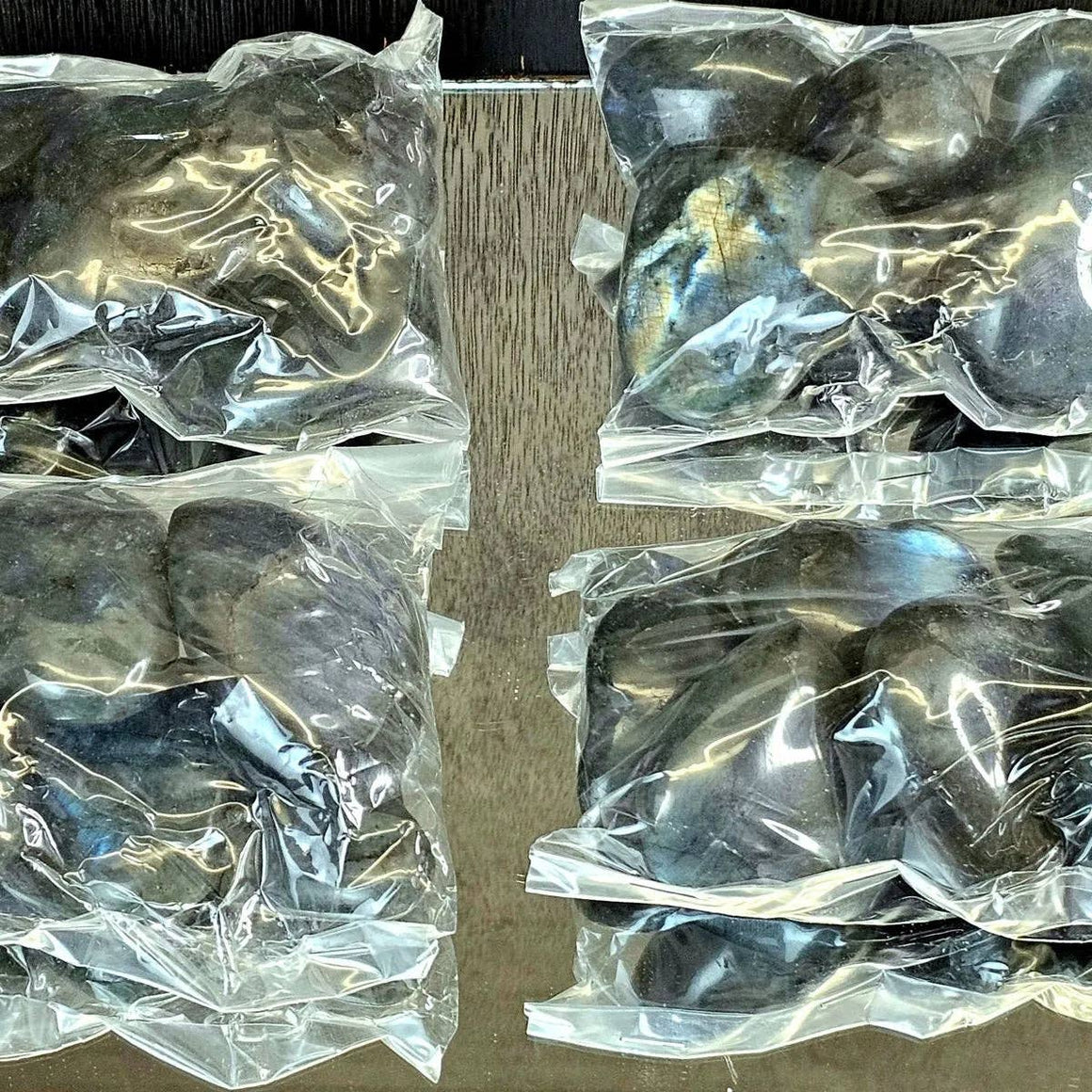 Plastic-wrapped metal objects on a cardboard surface