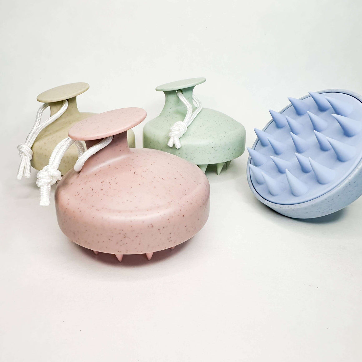 Set of four textured containers in pastel colors on a white background