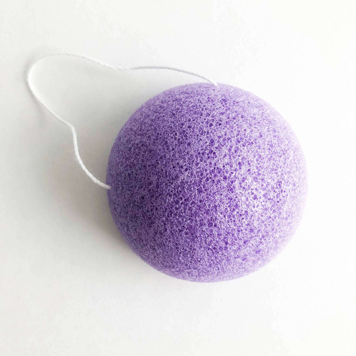 Purple konjac sponge on a white background