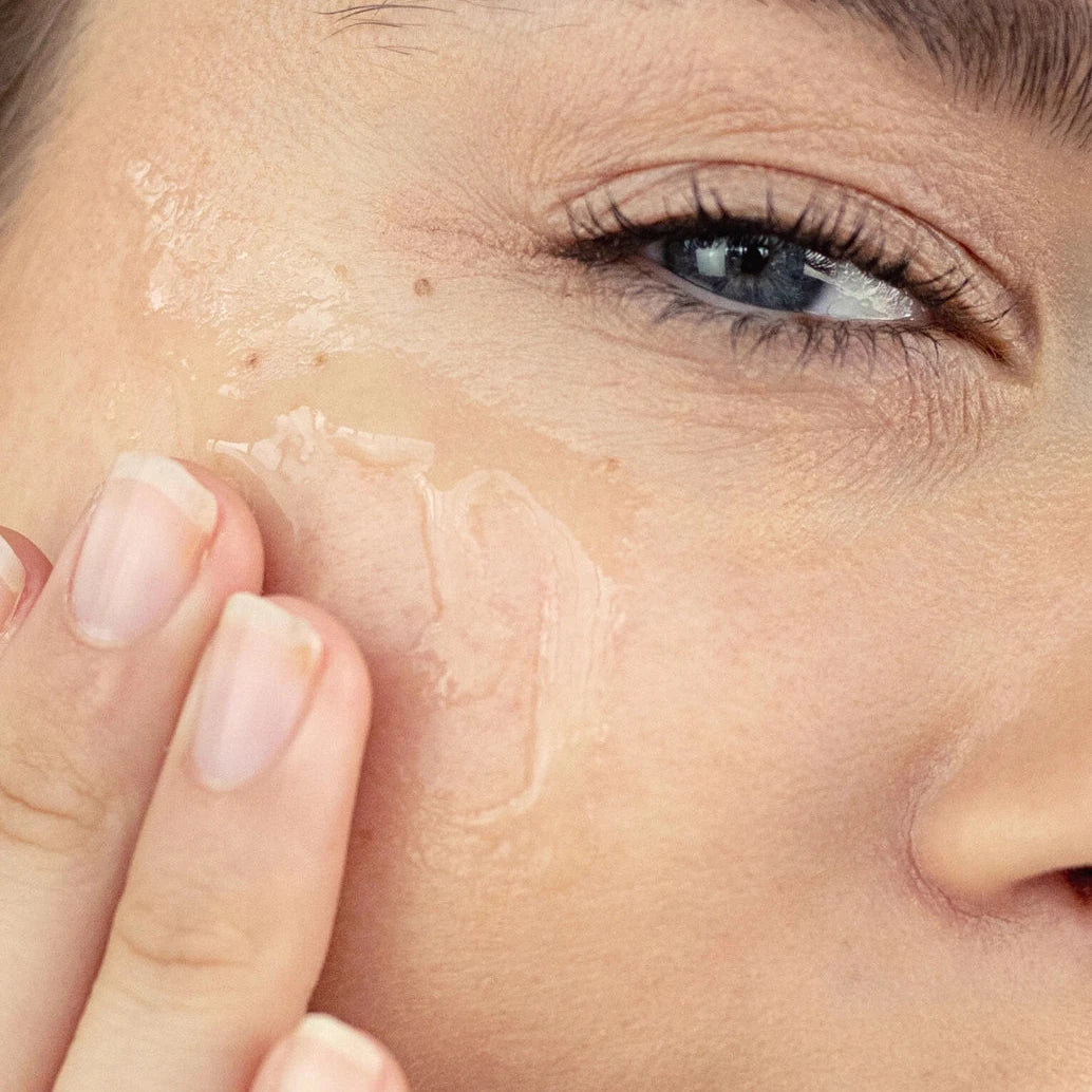 Close-up of a woman applying skincare product to her face