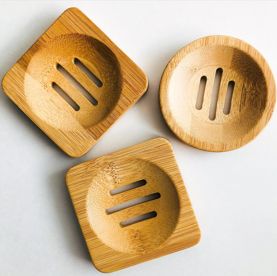 Three wooden soap dishes on a light gray background