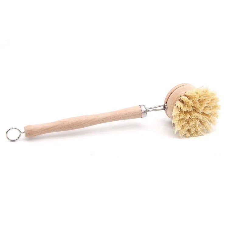 Dish brush with wooden handle and natural bristles on a white background