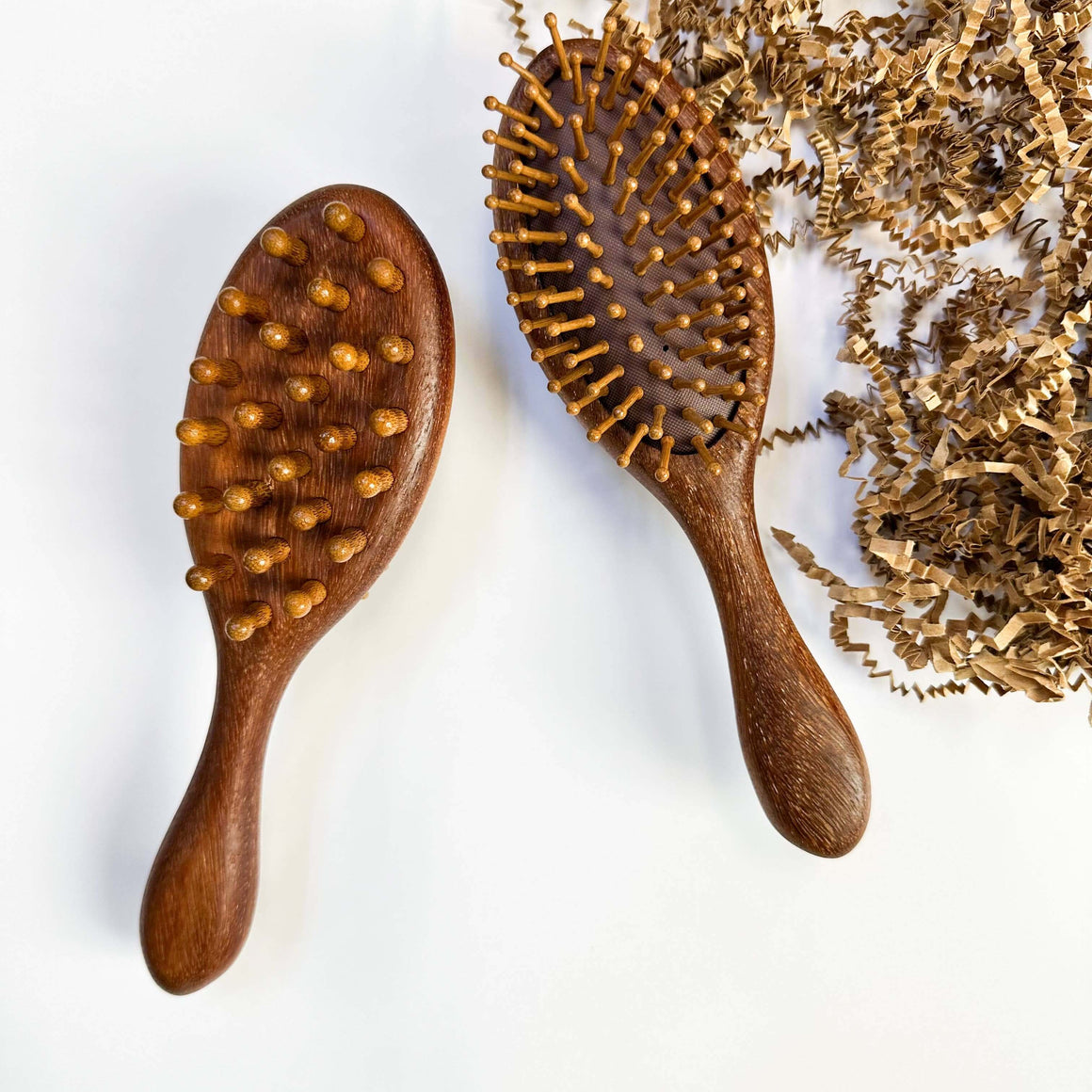 Two wooden hairbrushes with bristle heads on a white background