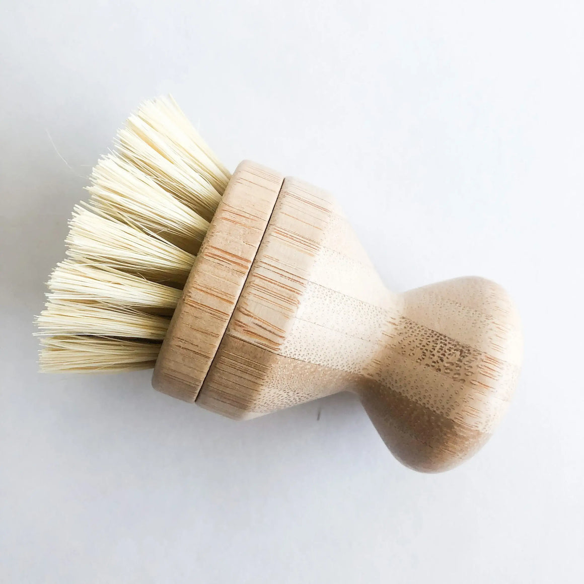 Wooden dish brush with bristles on a white background
