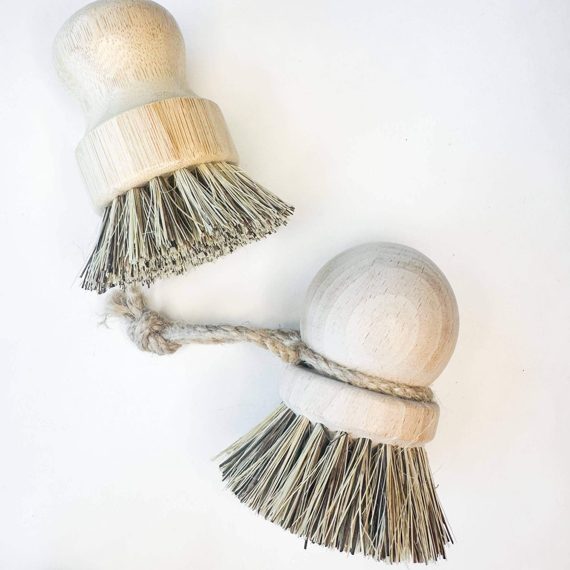 Two wooden dish brushes with bristle heads on a white background