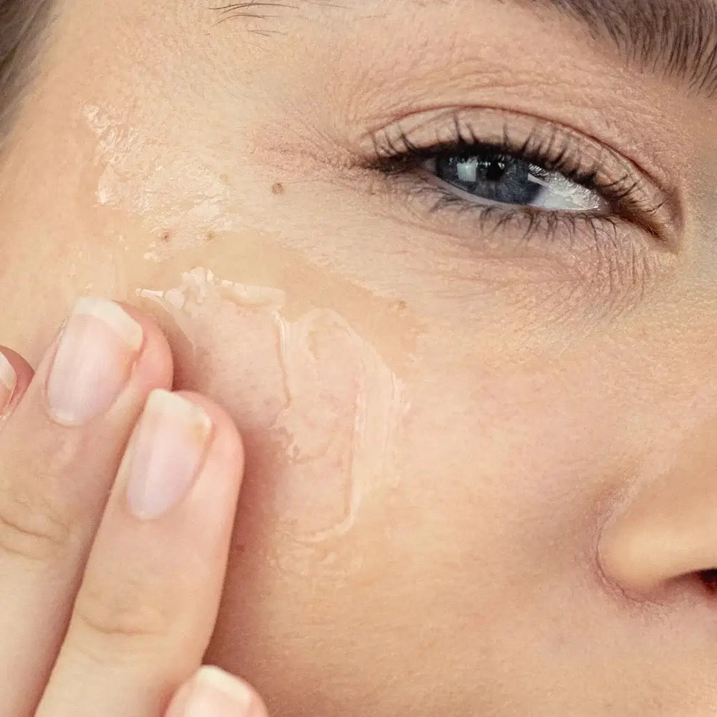 Close-up of a woman applying skincare product to her face