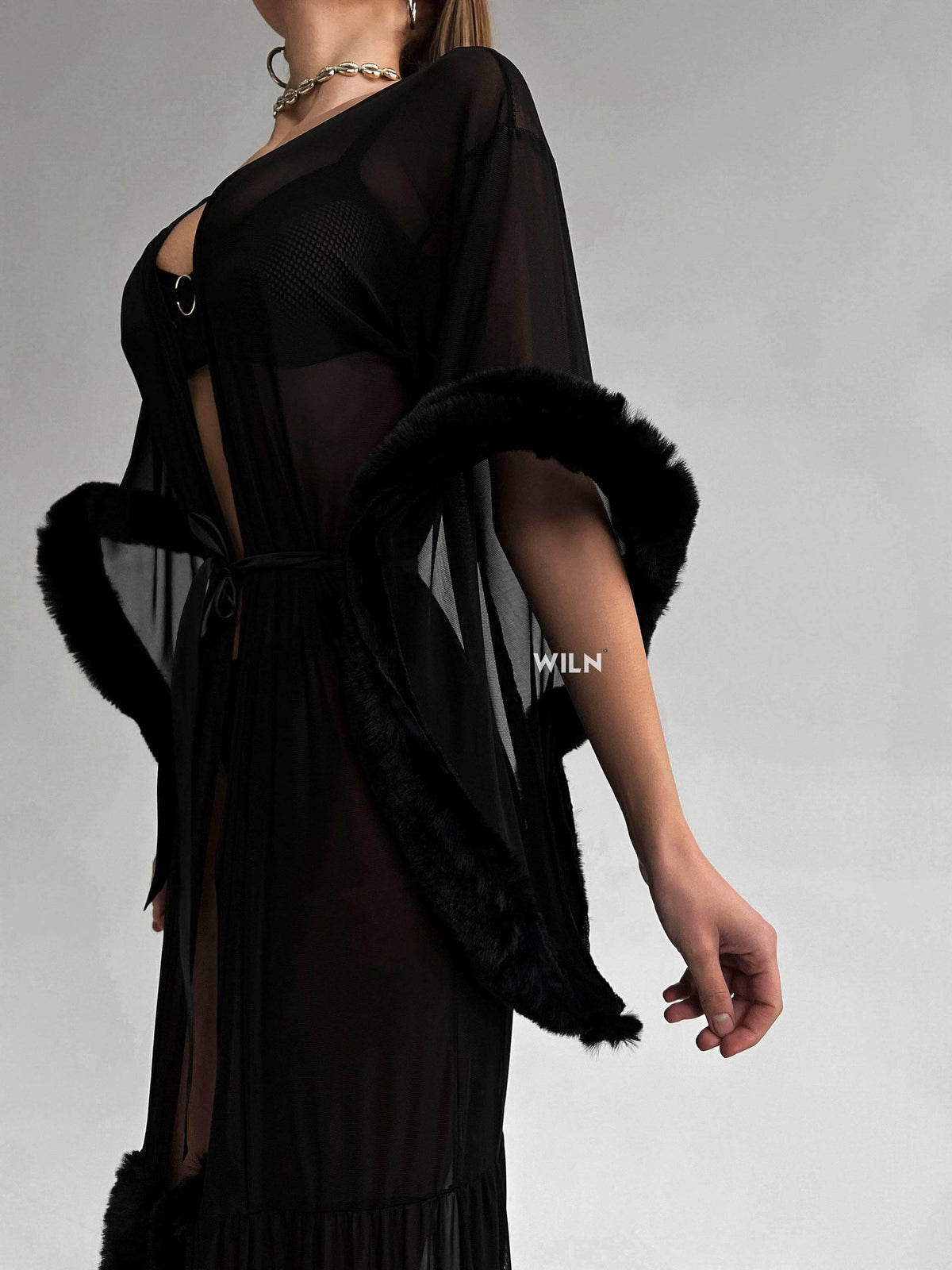 Model showcasing the BURLESQUE Soft Mesh Dress with luxurious black mesh fabric and dramatic sleeves.