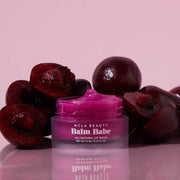 Purple lip balm jar labeled 'Balm Babe' with cherries on a pink background