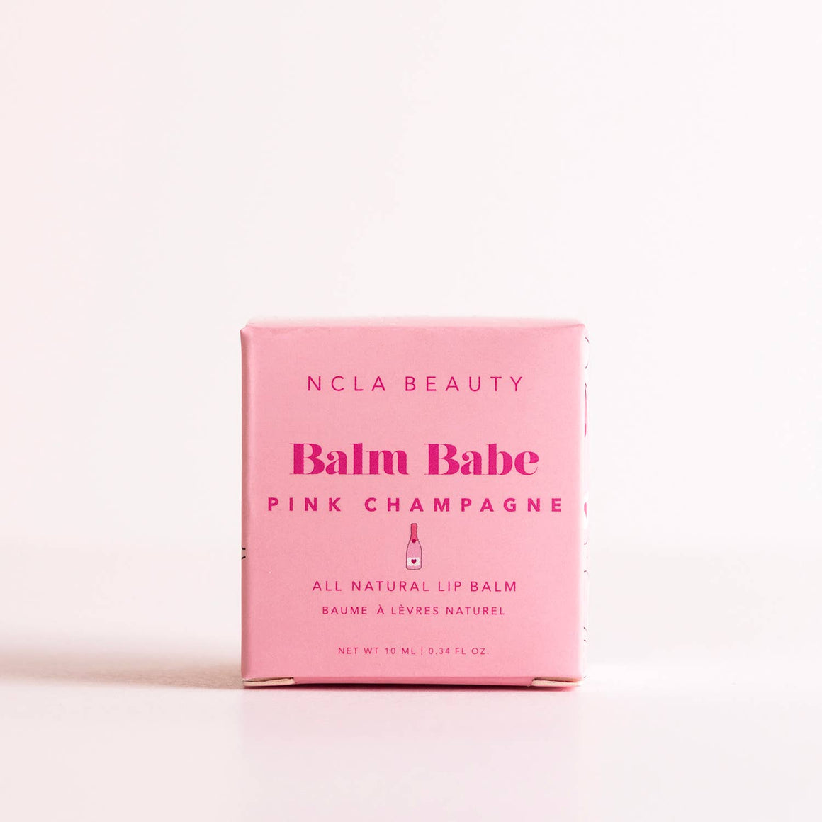 Pink lip balm packaging with 'NCLA Beauty' branding on a light pink background
