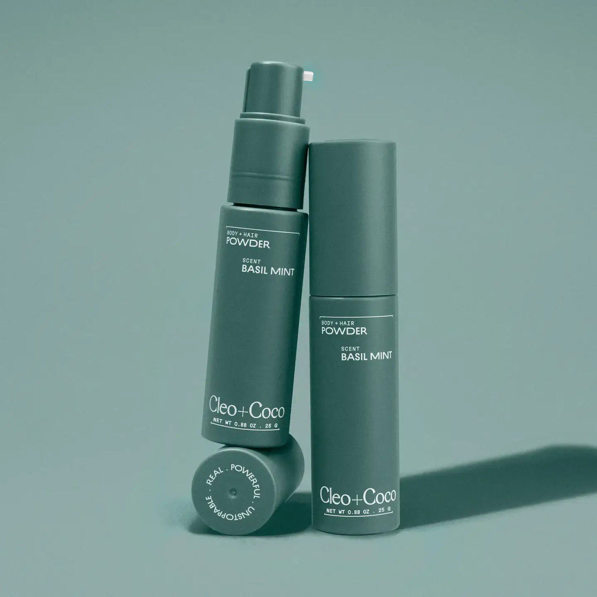 Two green bottles labeled 'Cleo+Coco' on a matching green background