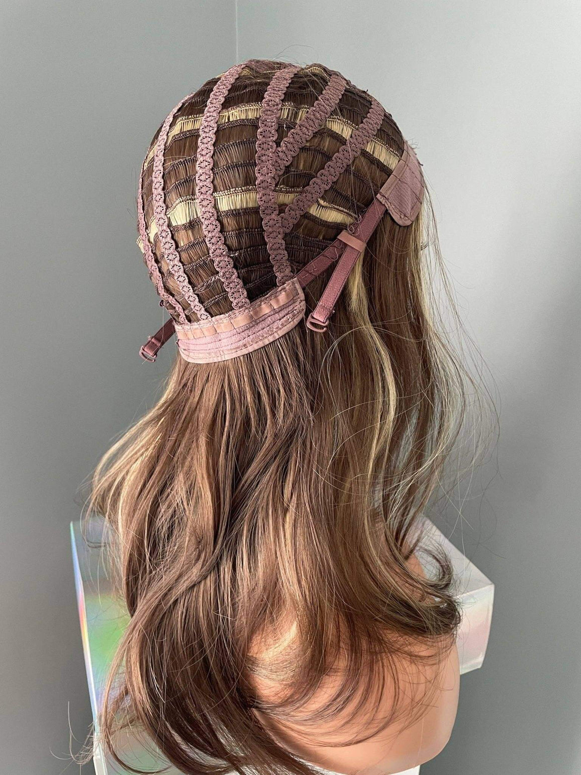 Brown wig with a lace front on a mannequin head against a gray background