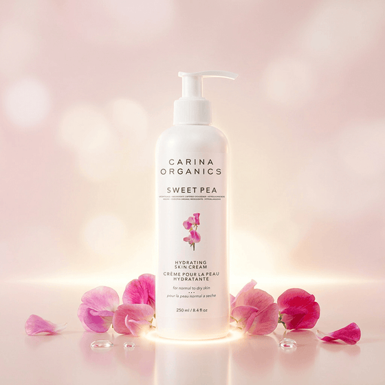 Carina Organics Sweet Pea hydrating body cream with pink flower petals on a soft pink background