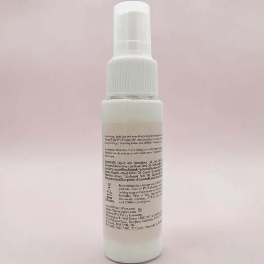 White spray bottle with text on a light pink background