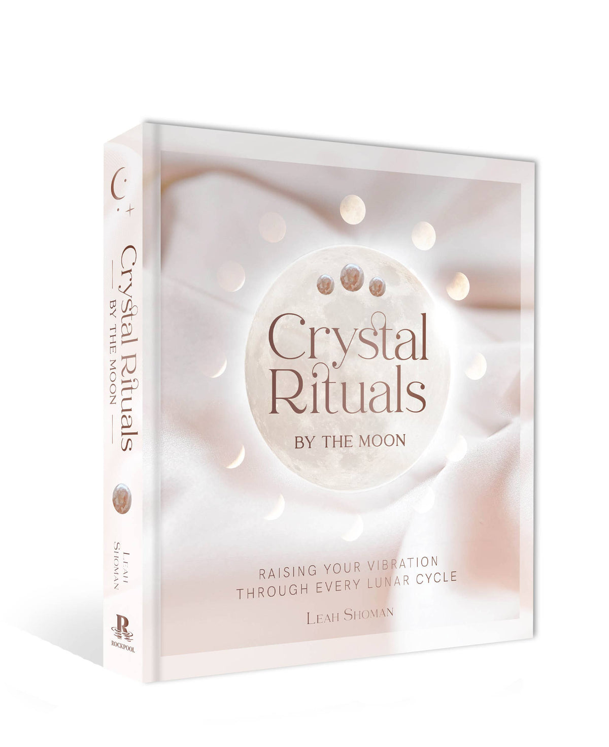 Book titled 'Crystal Rituals by the Moon' with a soft pink and white design on a white background