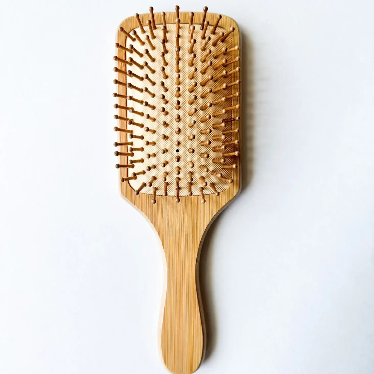 Wooden paddle hairbrush on a white background