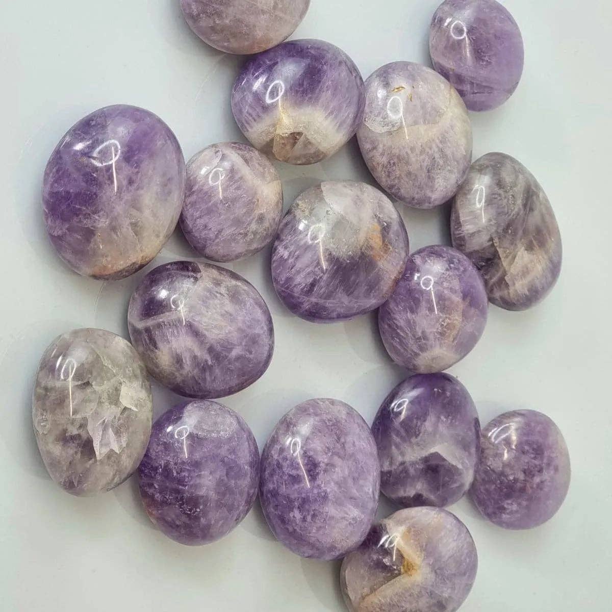 Collection of purple and gray marbled stones on a white background