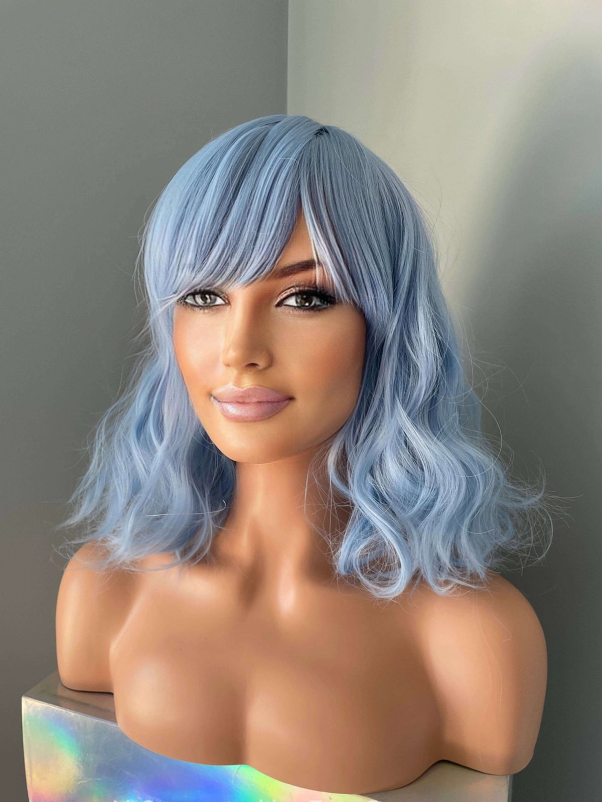 Faye Short Pastel Blue Body Wave Wig with Bangs displayed on a mannequin against a neutral background.