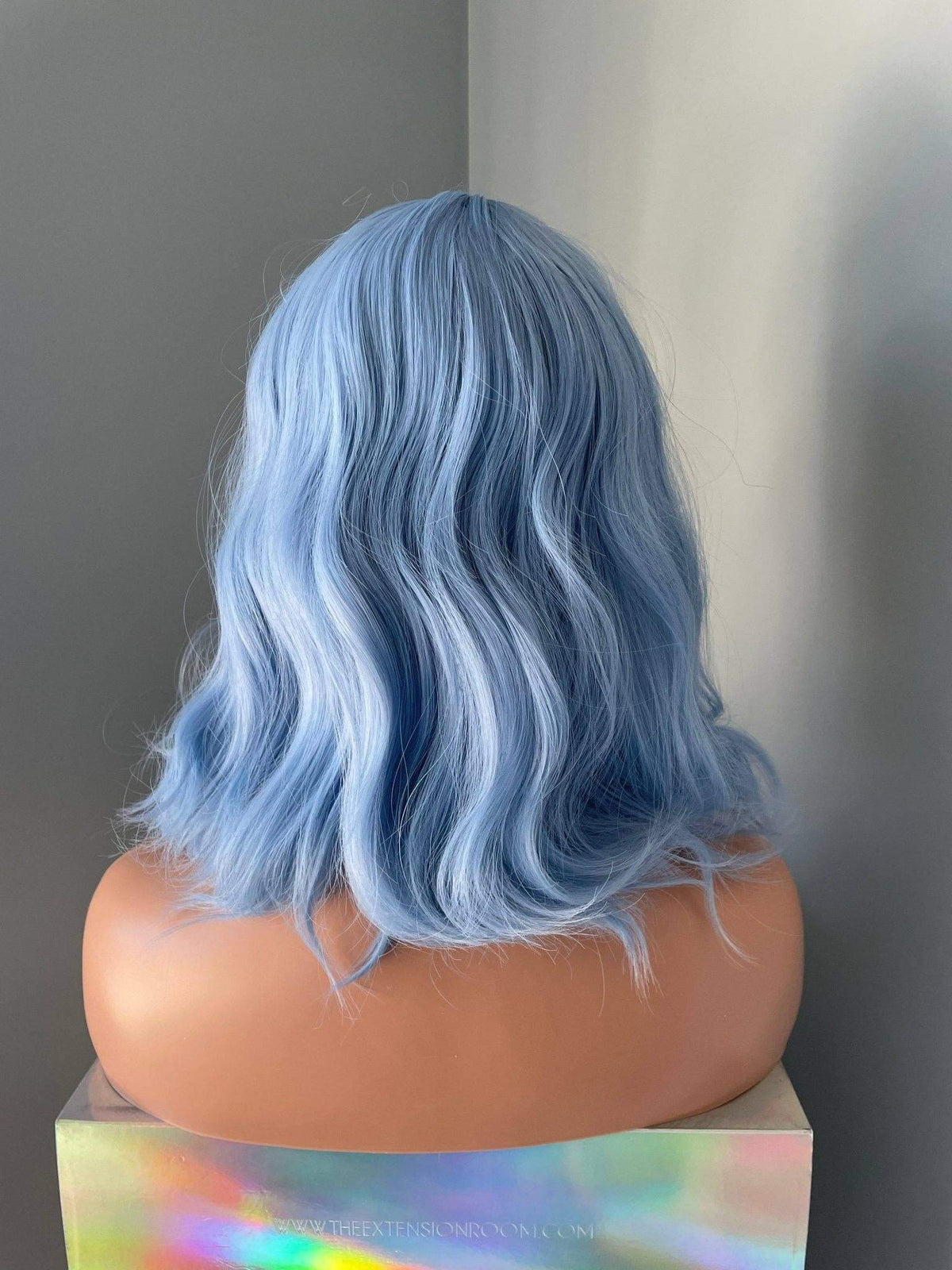 Back view of Faye short pastel blue body wave wig with bangs, showcasing soft waves and a chic bob style.