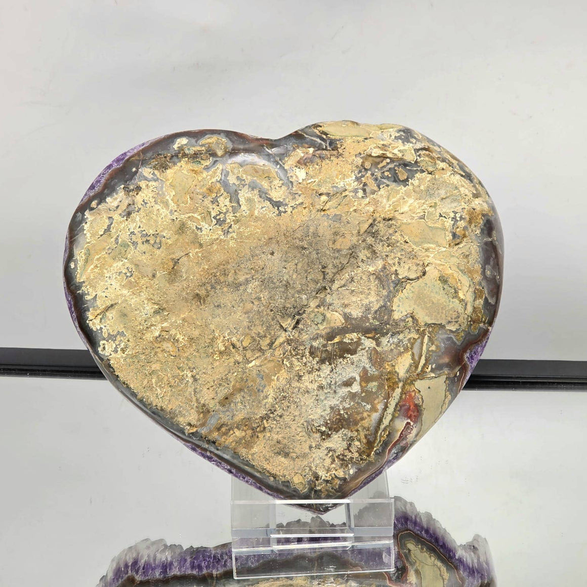Heart-shaped stone on a stand with a gray background