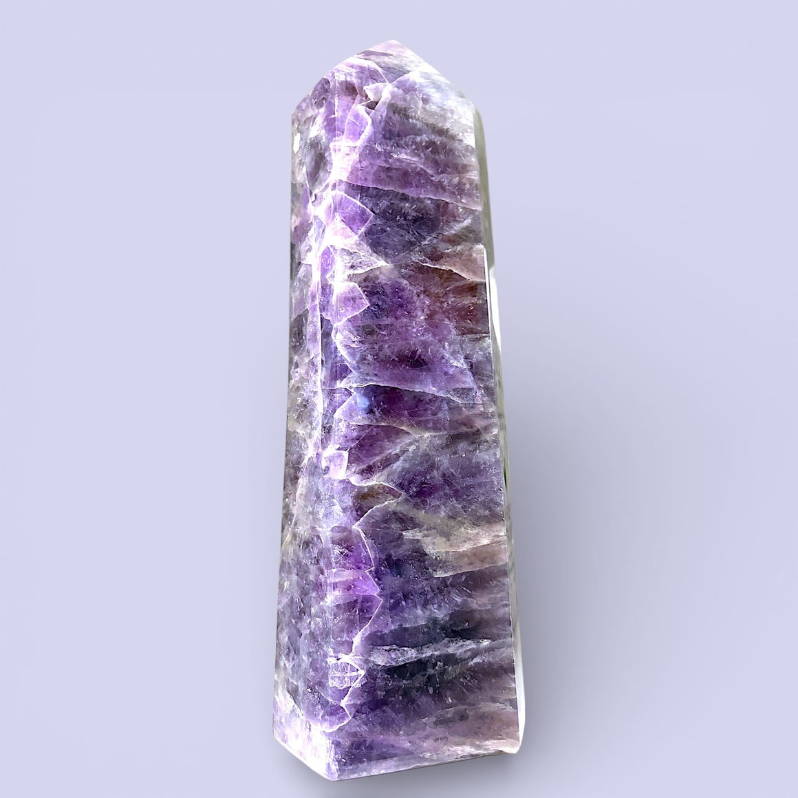 Amethyst crystal tower on a light purple background