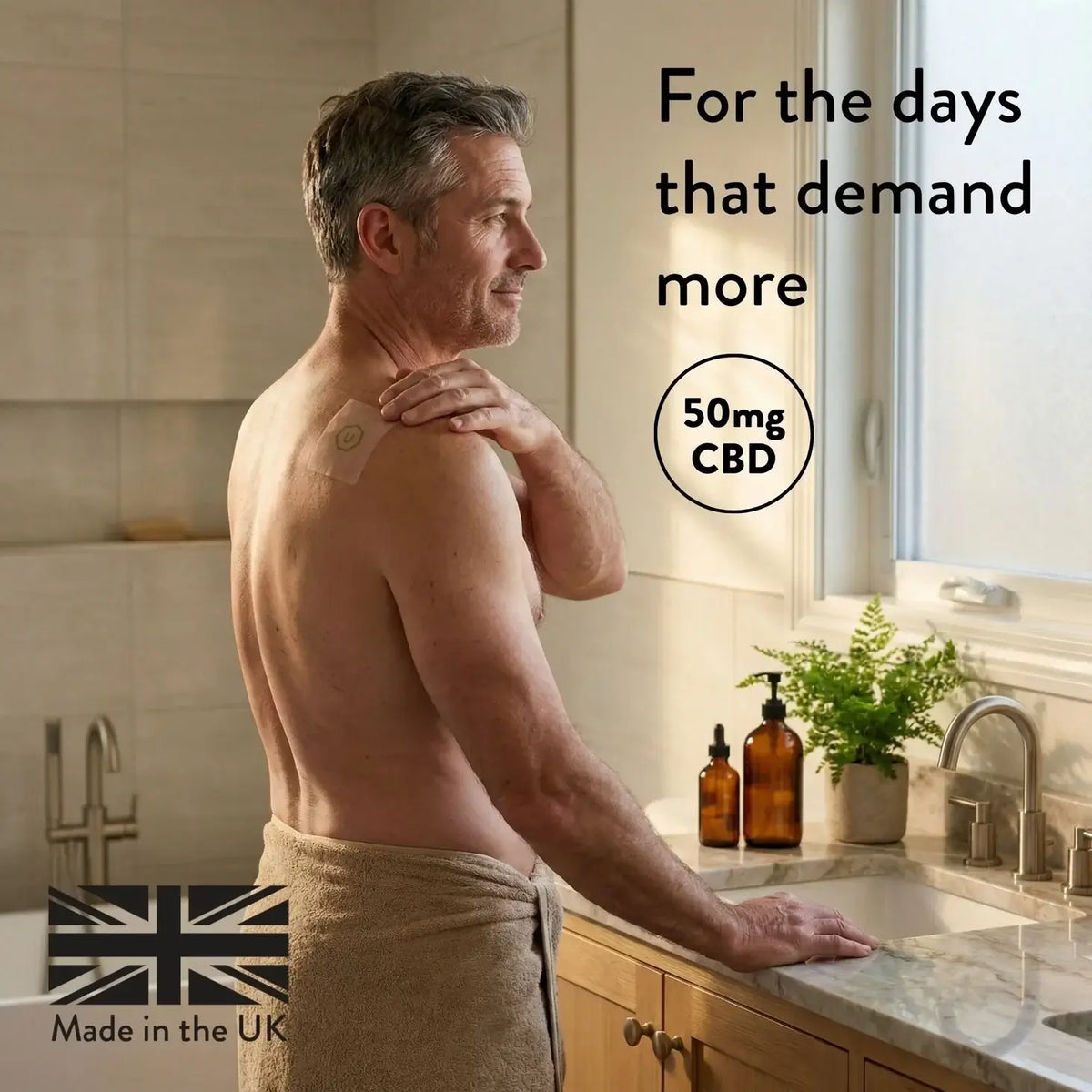 Man applying a CBD patch on his shoulder in a bathroom.