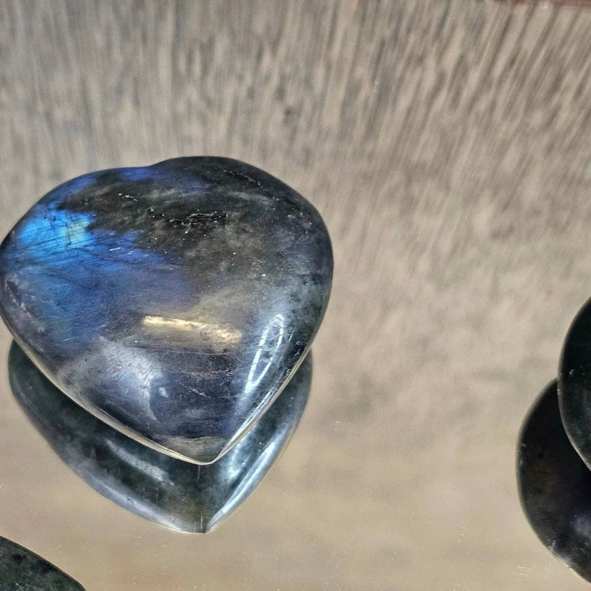 Heart-shaped labradorite stone on a wooden surface
