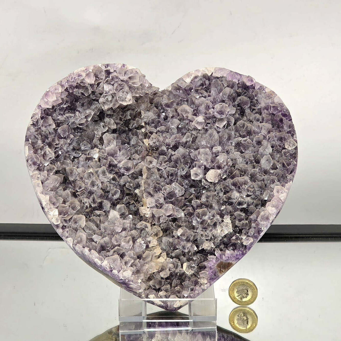 Heart-shaped crystal on a stand with a white background