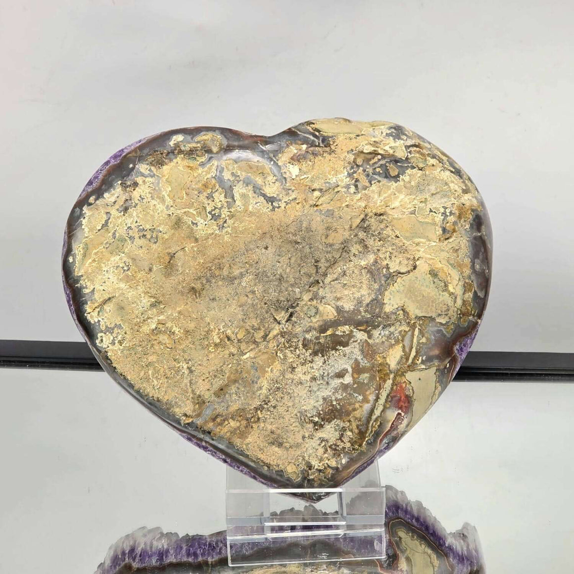 Heart-shaped stone on a stand with a gray background