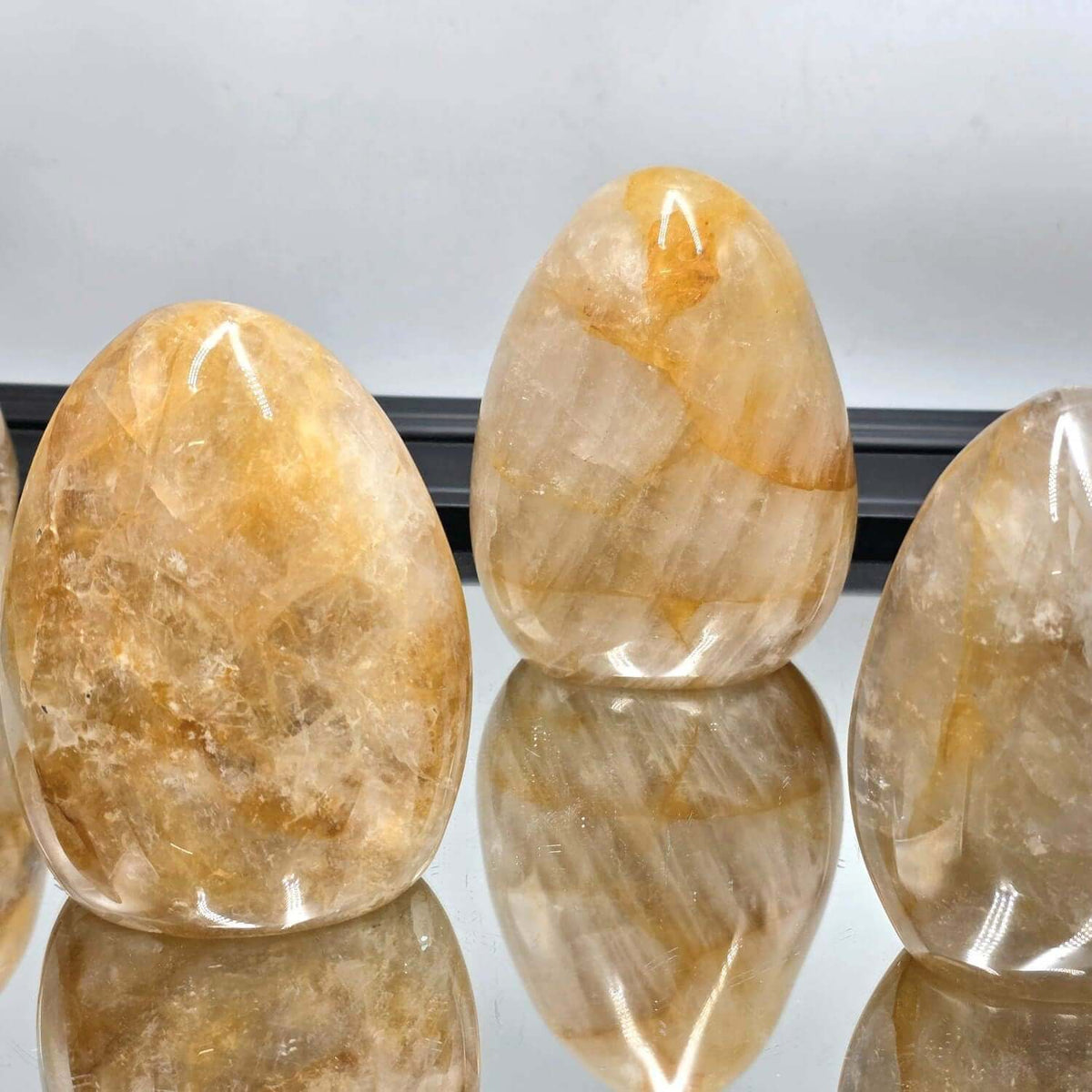 Oval-shaped stones with a reflective surface on a white background