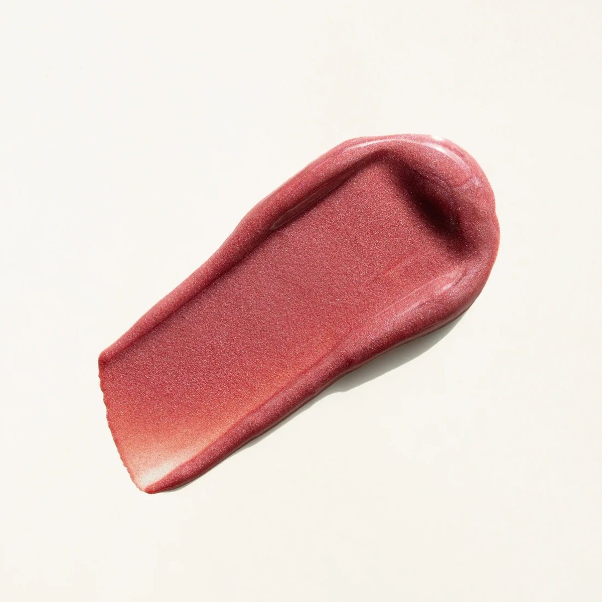 Pink lipstick swatch on a beige background