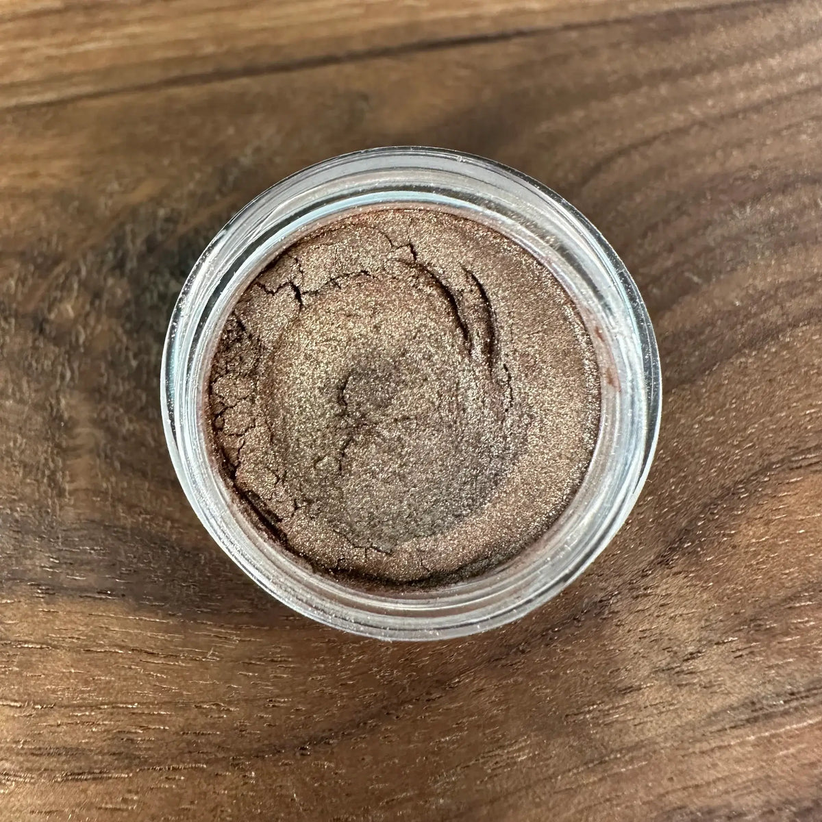 Jar of brown powder on a wooden surface