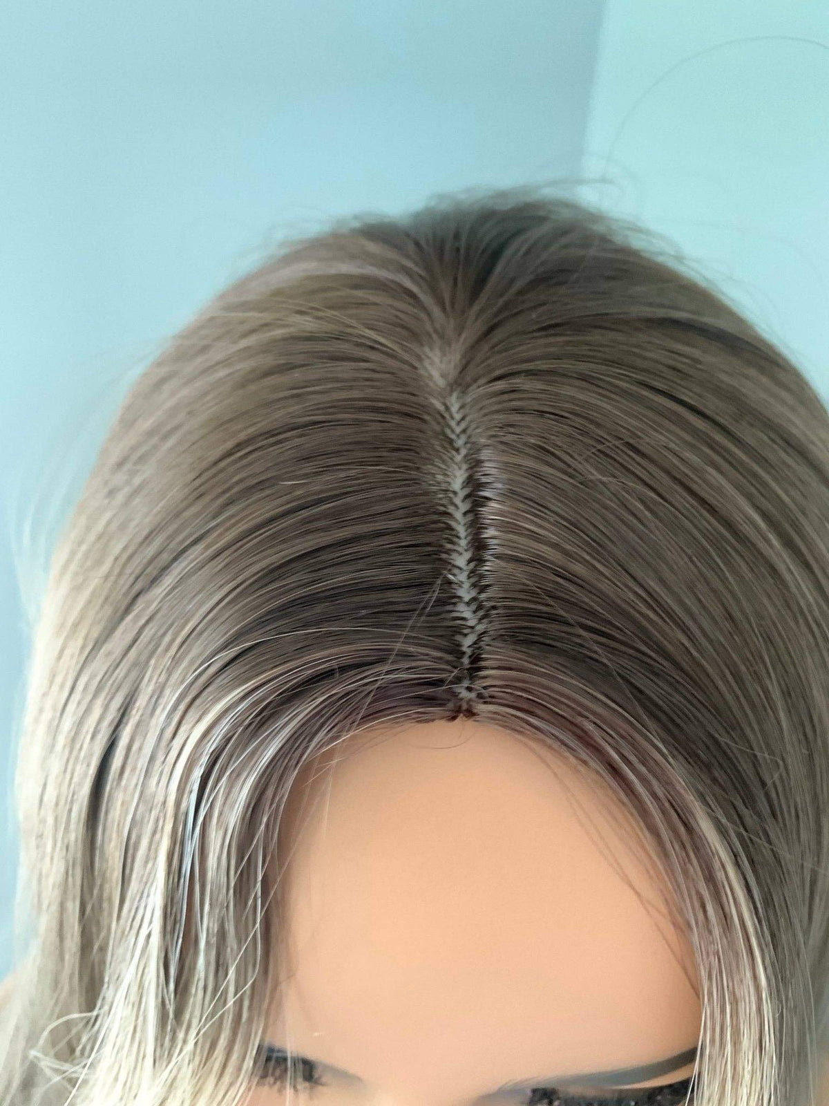 Mannequin head with a gray wig on a light blue background