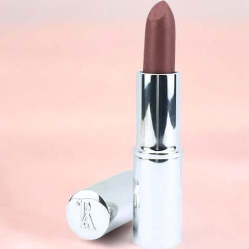 Lipstick with silver casing on a pink background