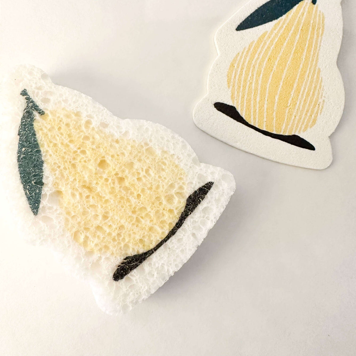Two coasters with pear designs on a light gray background