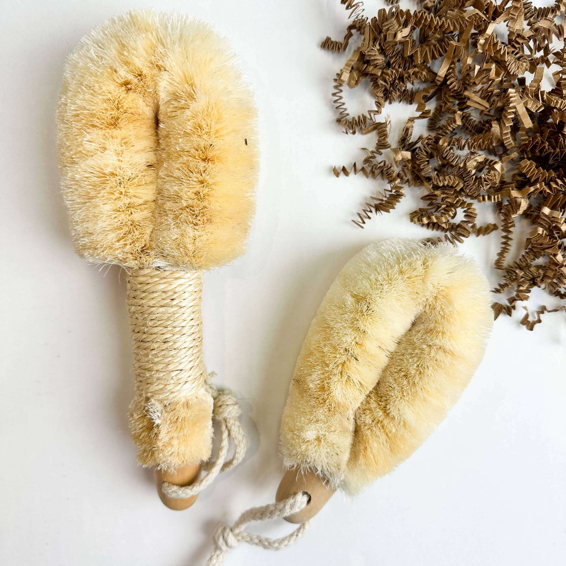 Two natural fiber brushes on a white background with脱落的刷毛.