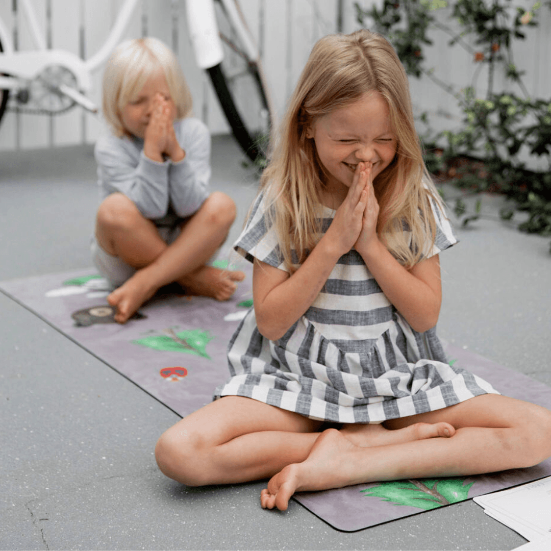 Children practicing yoga on the Nature Print Kids Yoga Mat, smiling and in a mindful pose.