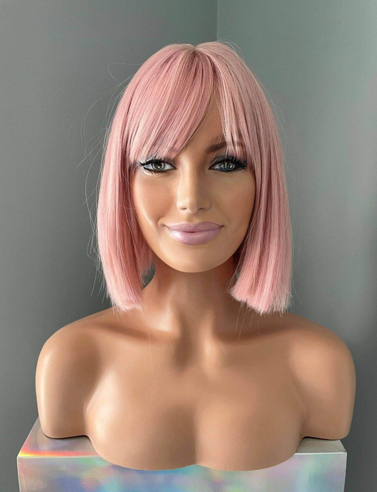 Nia Short Baby Pink Bob Wig on mannequin showcasing its pastel pink color and full bangs.