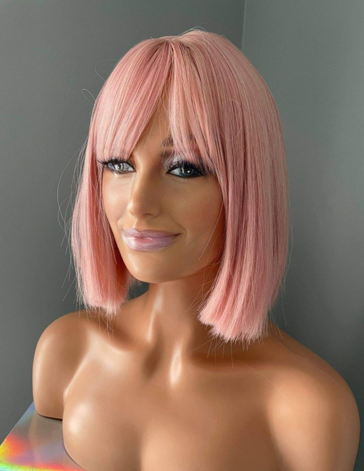 Nia Short Baby Pink Bob Wig showcasing soft pastel pink tones and bangs on a mannequin head